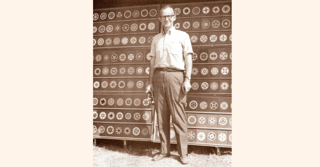 Don Yoder standing in front of hex sign board
