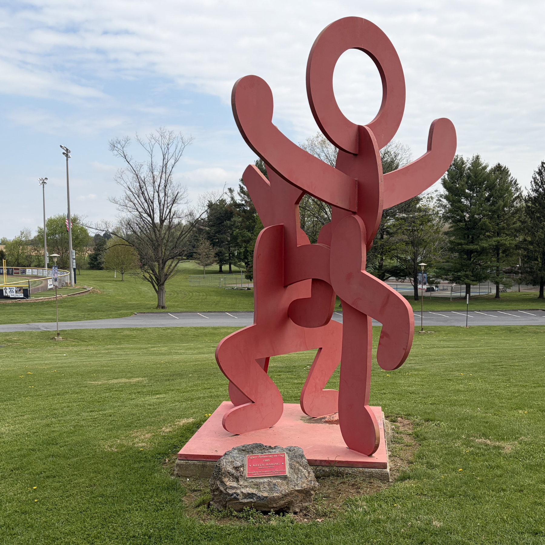 Figure Balancing on Dog Sculpture by Keith Haring in Kutztown Park